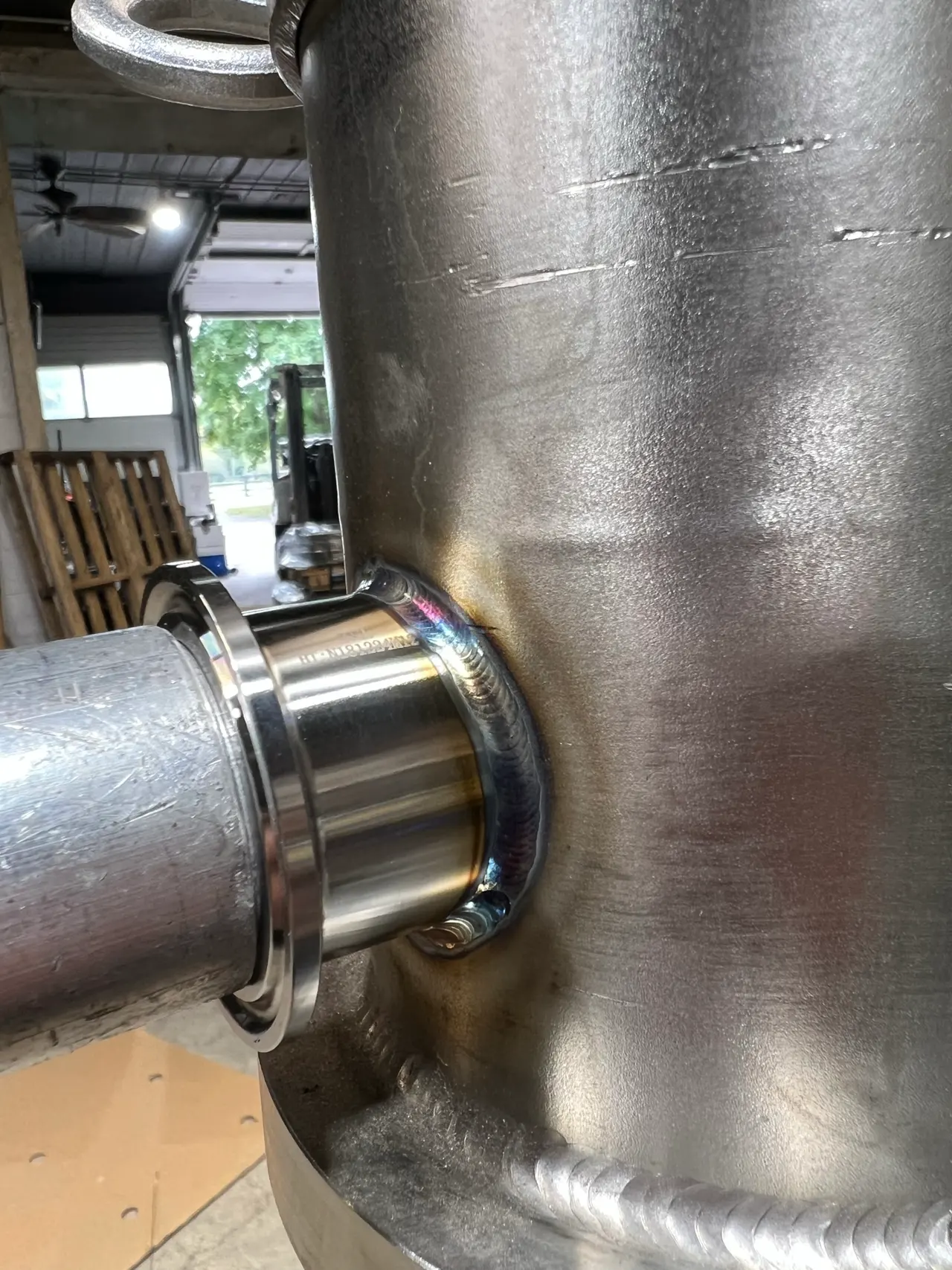 TIG weld joining a stainless branch fitting to a cylindrical vessel