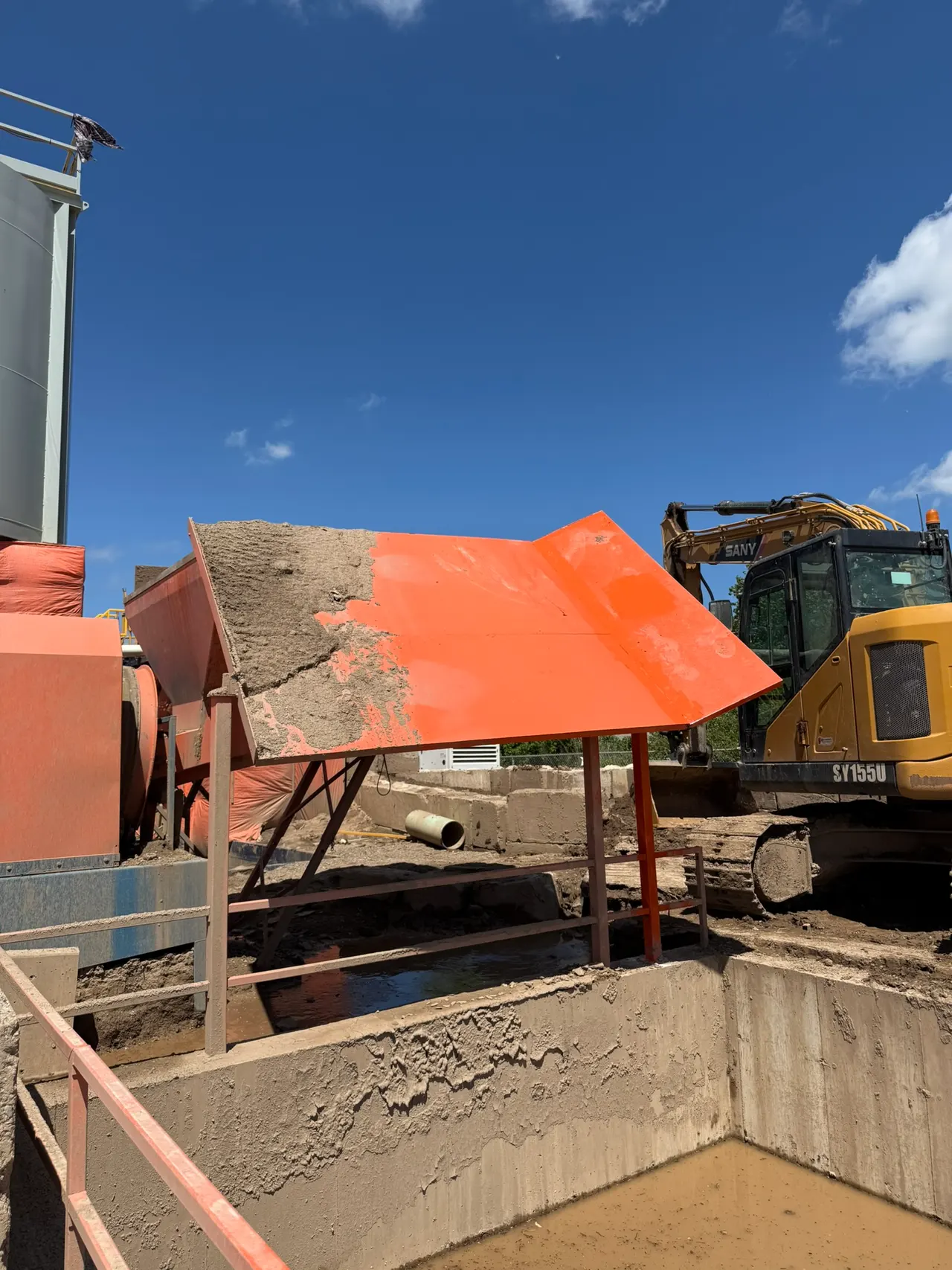 Orange fabricated steel chute standing on legs at the washout plant
